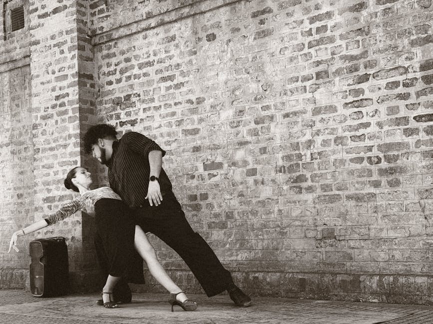Captivating tango dancers performing in front of a brick wall in Buenos Aires, Argentina.